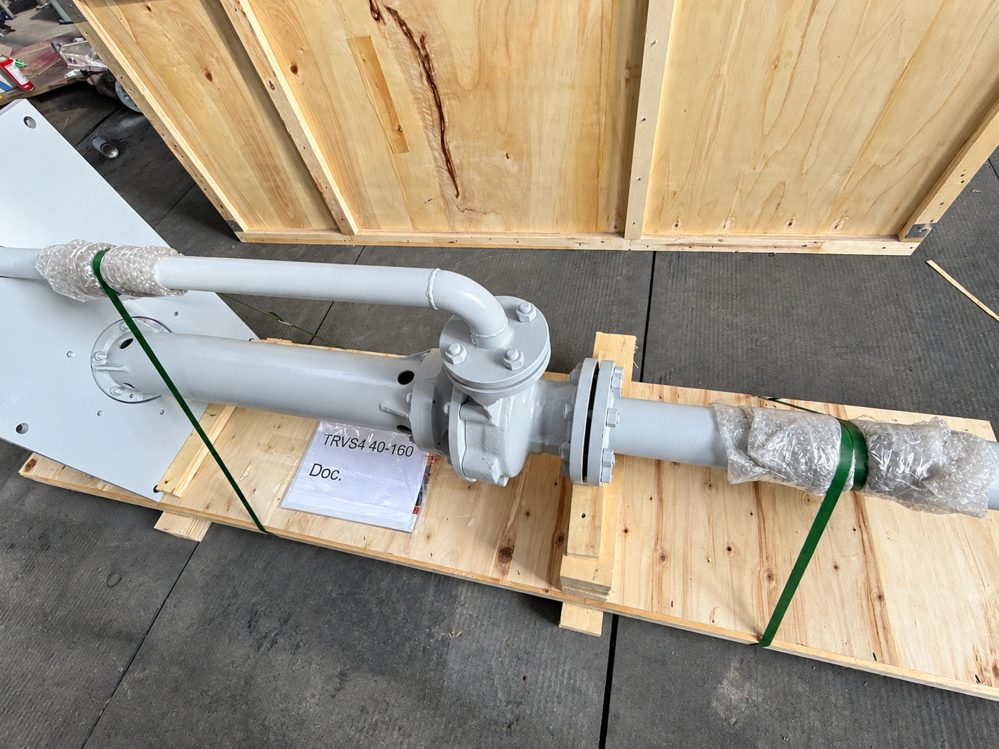 Nahansicht von Pumpentragrohr und separater Druckleitung auf Holzunterlagen.
